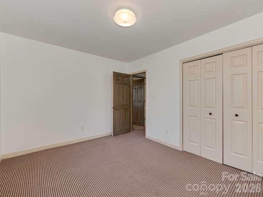 7244 Terrace Drive, Charlotte, NC 28211.  MLS# CAR4357695, YatesRealty ID 17887. Bedroom #3, located on the lower level, offers plenty of space, a luxuriously soft Berber carpet, and ample closet space, creating a comfortable and inviting retreat.