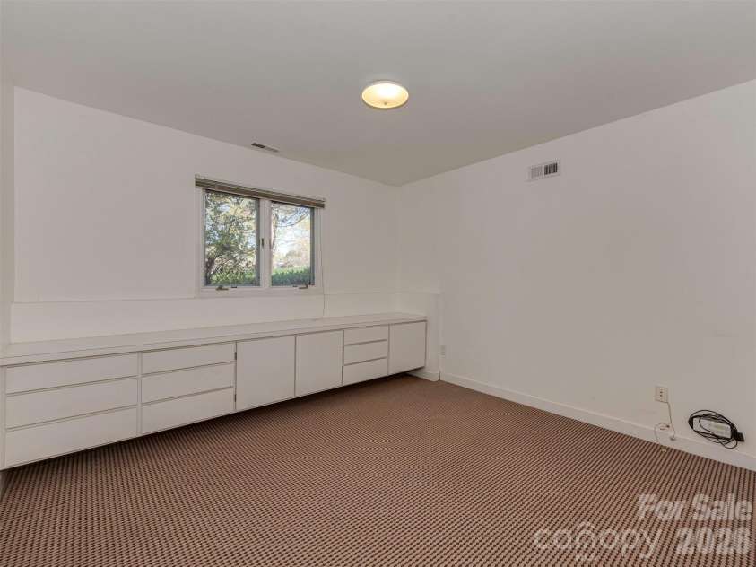 7244 Terrace Drive, Charlotte, NC 28211.  MLS# CAR4357695, YatesRealty ID 17887. Bedroom #4, located on the lower level, features built-ins that make it the perfect space for a bedroom, home office, or flexible living area.