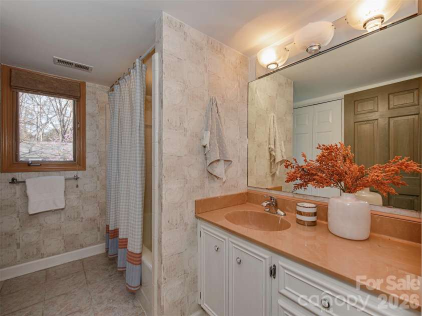 7244 Terrace Drive, Charlotte, NC 28211.  MLS# CAR4357695, YatesRealty ID 17887. This downstairs bathroom is full of character, featuring warm tones, textured walls, and a soft vintage charm that creates a cozy and inviting feel. Thoughtfully laid out with natural light and a touch of retro style, t