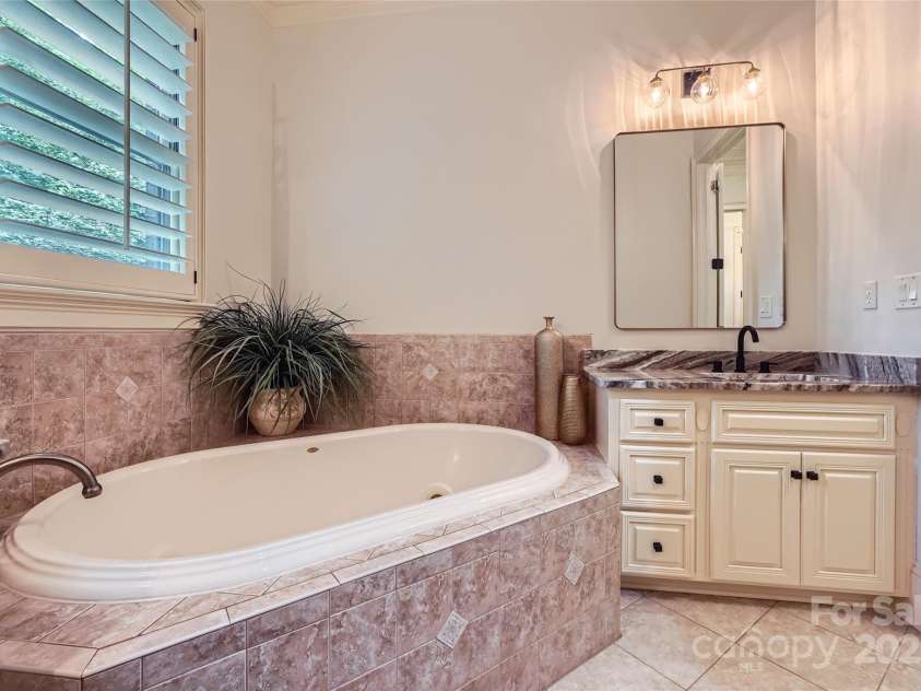 1056 James Madison Drive, Matthews, NC 28104.  MLS# CAR4260538, YatesRealty ID 17891. Primary bathroom tub, shower and separate sinks