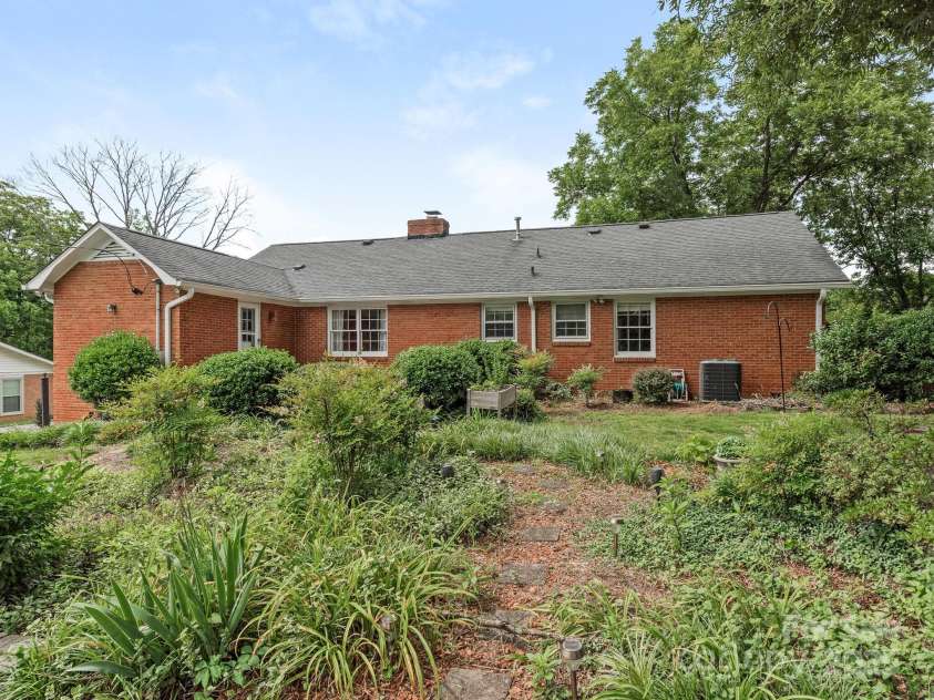 3408 Oak Tree Trail, Matthews, NC 28105.  MLS# CAR4267808, YatesRealty ID 17929. View of the rear of the house from the manicured garden