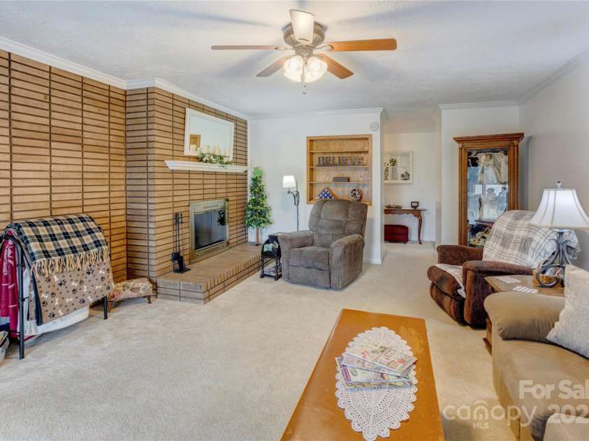 2004 Grandhaven Drive, Concord, NC 28027.  MLS# CAR4220214, YatesRealty ID 17934. Living room with large fireplace and sliding doors out to deck.