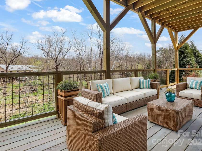 77 Creekside View Drive, Asheville, NC 28804.  MLS# CAR4109113, YatesRealty ID 17957. Lower level deck with treated wood floors. Virtually staged