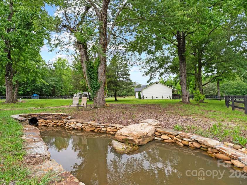 94 Jamestown Lane, Columbus, NC 28722.  MLS# CAR4262620, YatesRealty ID 17982. How cute is this! Lovely creek and check out this pond feature !