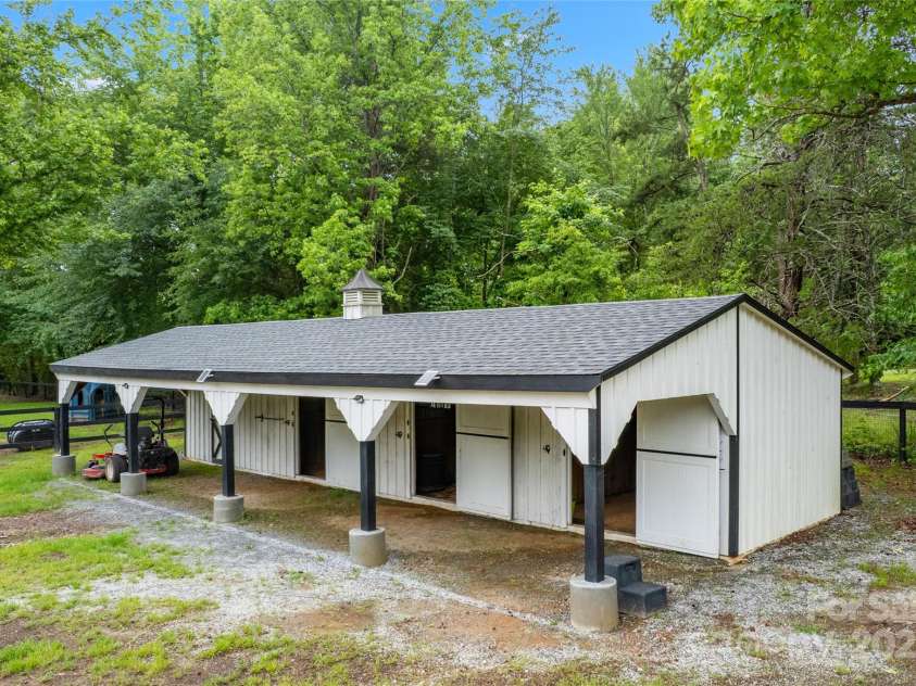 94 Jamestown Lane, Columbus, NC 28722.  MLS# CAR4262620, YatesRealty ID 17982. Shed row barn with three 12x12 stalls and a feed room.