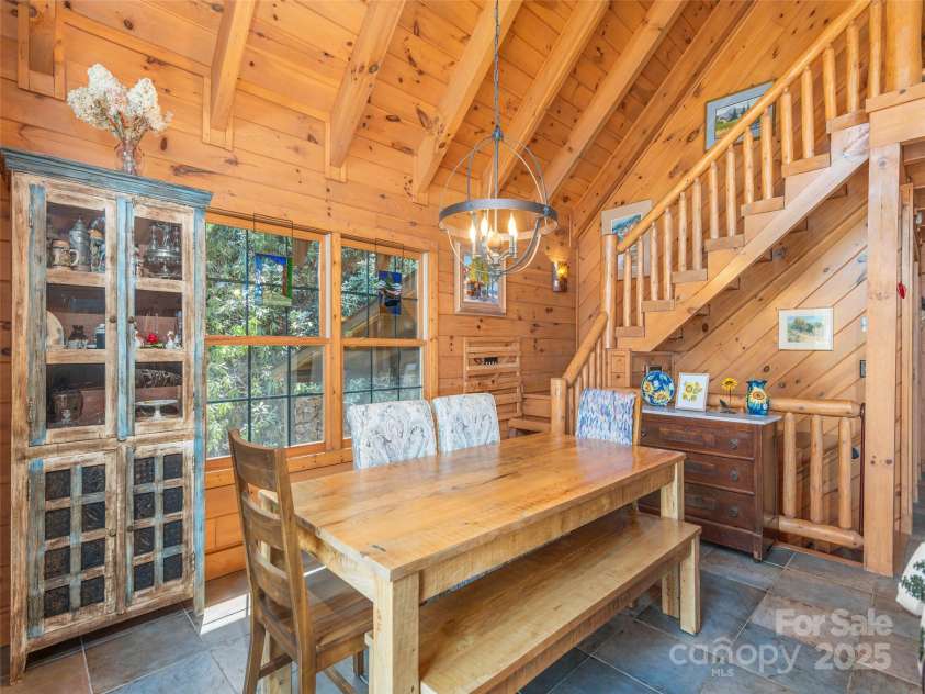90 Junco Trail, Waynesville, NC 28785.  MLS# CAR4252158, YatesRealty ID 18032. Dining area leading to custom log beam stairs to the loft