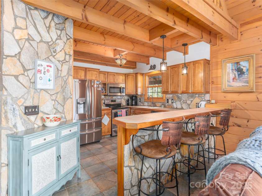 90 Junco Trail, Waynesville, NC 28785.  MLS# CAR4252158, YatesRealty ID 18032. Kitchen with Stone accents, tile countertop and all stainless steel appliances