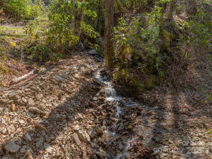 90 Junco Trail, Waynesville, NC 28785.  MLS# CAR4252158, YatesRealty ID 18032. Multiple Streams visible from covered porches and deck