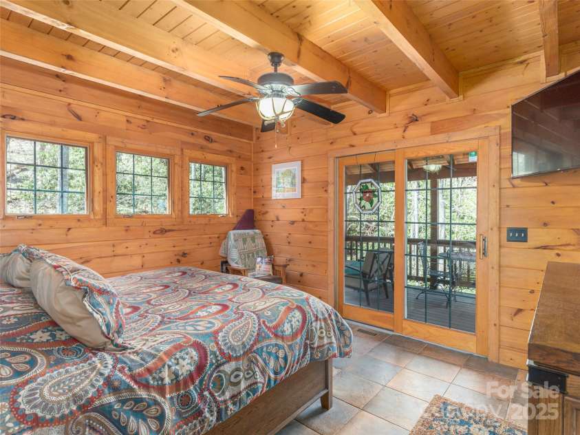 90 Junco Trail, Waynesville, NC 28785.  MLS# CAR4252158, YatesRealty ID 18032. Primary King Size Bedroom facing the rushing stream just outside your sliding glass windows onto your upper porch area.