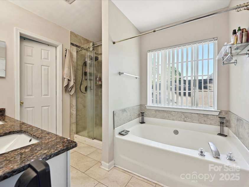 7923 Shiny Meadow Lane, Charlotte, NC 28215.  MLS# CAR4252293, YatesRealty ID 18034. The updated Owner's Bath features Granite Vanity tops, Ceramic tile flooring.