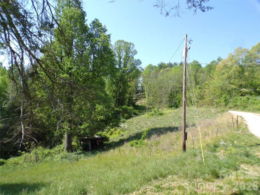 202 Honor Lane, Hendersonville, NC 28792.  MLS# CAR4345433, YatesRealty ID 18074. Land view with driveway on right side