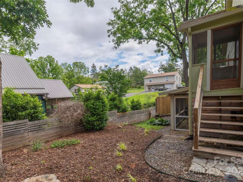 7 Grove Street, Weaverville, NC 28787.  MLS# CAR4262820, YatesRealty ID 18128. Back yard with entrance to main level up steps and also lower level area Door