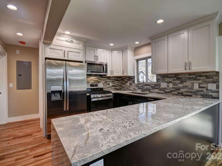 20 Lisa Lane, Maggie Valley, NC 28751.  MLS# CAR4126397, YatesRealty ID 182. Kitchen with Water Fall Granite Counter Top & Tile Backsplash - SS Gas Range- SS DBL Door Refrigerator Microwave/Vent hood - vented to the outside - Commercial Faucet with Pot Filler - Kohler Sink