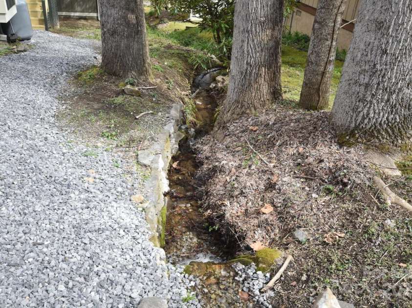 20 Lisa Lane, Maggie Valley, NC 28751.  MLS# CAR4126397, YatesRealty ID 182. Small Mountain Stream on Right Side of the Home