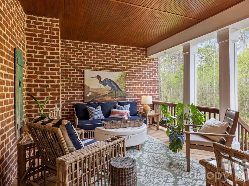 3143 James Plantation Drive, Denver, NC 28037.  MLS# CAR4366315, YatesRealty ID 18210. Comfortable covered porch space ideal for relaxing or entertaining while enjoying the private wooded surroundings.