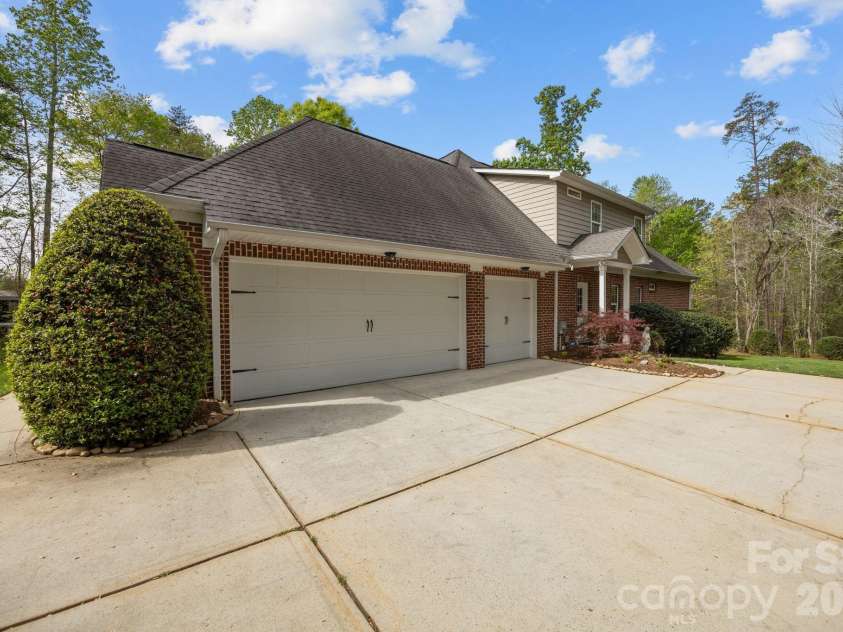 3143 James Plantation Drive, Denver, NC 28037.  MLS# CAR4366315, YatesRealty ID 18210. Spacious 3-car side-load garage with extended driveway, offering ample parking, storage, and easy maneuverability.