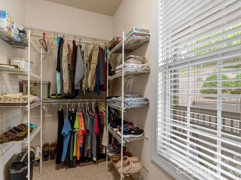 112 Chestnut Lane, Hendersonville, NC 28792.  MLS# CAR4369682, YatesRealty ID 18244. Walk-in closet with multiple shelves and natural lighting from window overlooking front porch.