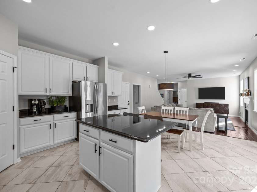 347 Wildbriar Road, Fletcher, NC 28732.  MLS# CAR4250812, YatesRealty ID 18254. The open-concept kitchen flows seamlessly into the spacious family room, highlighted by a cozy fireplace, creating a bright and inviting space for both relaxation and entertaining