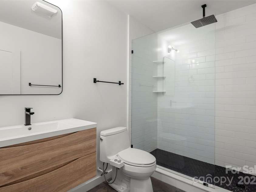 79 Euclid Boulevard, Asheville, NC 28806.  MLS# CAR4253101, YatesRealty ID 18258. Lower level full bathroom with a modern tiled shower