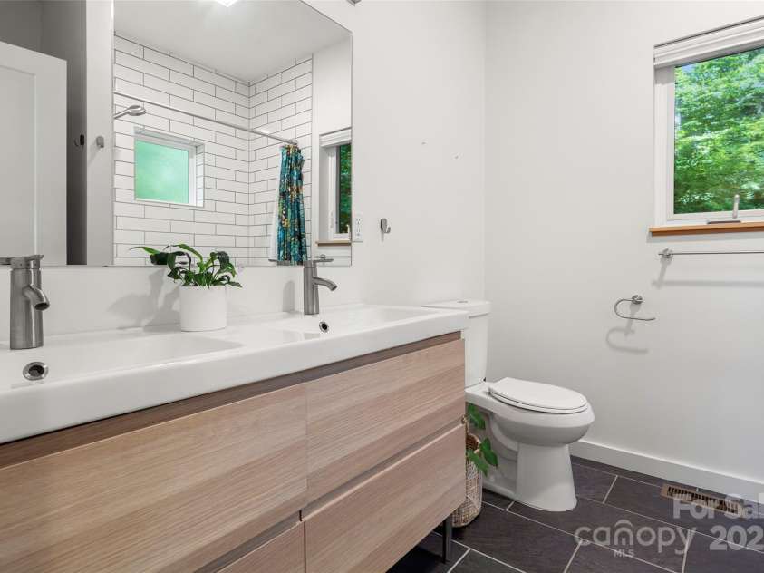 79 Euclid Boulevard, Asheville, NC 28806.  MLS# CAR4253101, YatesRealty ID 18258. Primary bathroom with double vanity and tub/shower combo.