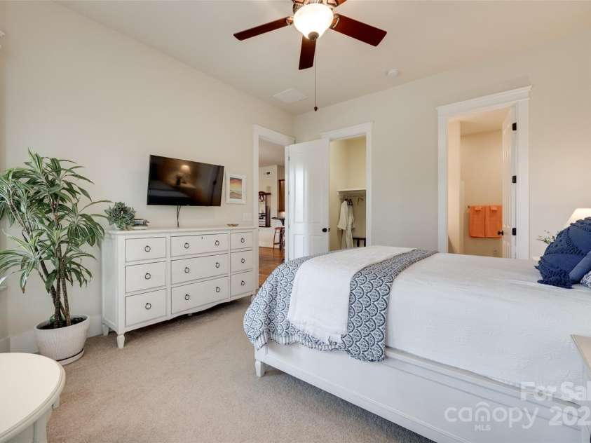 18311 Rosapenny Road, Charlotte, NC 28278.  MLS# CAR4256637, YatesRealty ID 18305. Comfortable guest suite featuring neutral tones, ceiling fan, and direct access to a private bath.