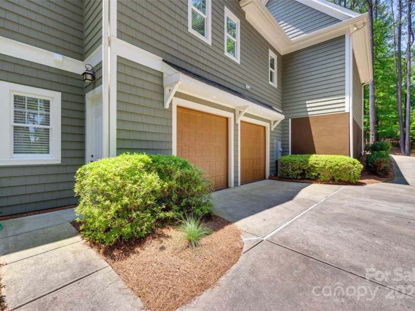 18311 Rosapenny Road, Charlotte, NC 28278.  MLS# CAR4256637, YatesRealty ID 18305. Dual side-entry garage doors offer private access to the lower-level workshop and provide seamless connection to the yard and lake path.
