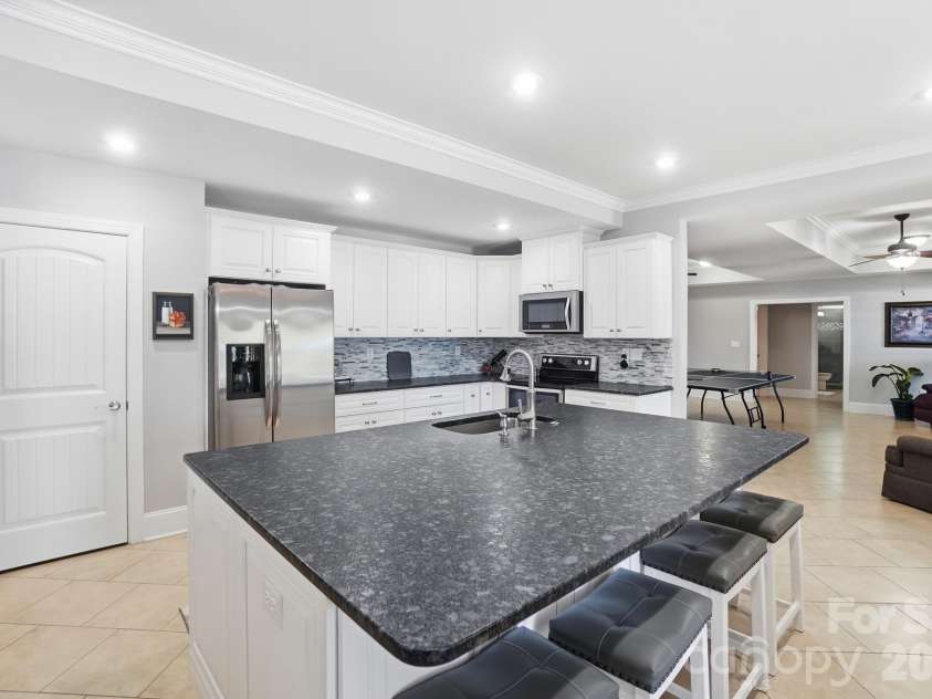 159 Riverchase Lane, Mooresville, NC 28115.  MLS# CAR4372819, YatesRealty ID 18318. LOWER LEVEL KITCHEN WITH LEATHERED GRANITE