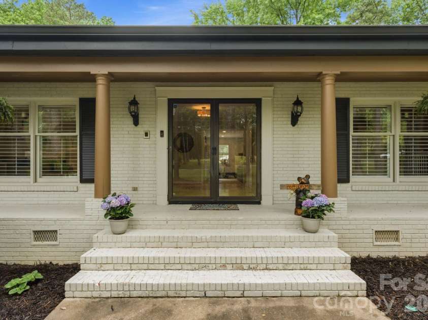 20200 Floral Lane, Cornelius, NC 28031.  MLS# CAR4374755, YatesRealty ID 18352. Large rocking chair front porch