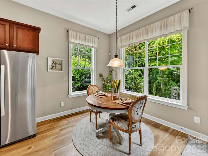 18721 The Commons Boulevard, Cornelius, NC 28031.  MLS# CAR4373232, YatesRealty ID 18371. Bright and cheerful breakfast nook surrounded by windows, offering serene backyard views and the perfect spot for casual dining.
