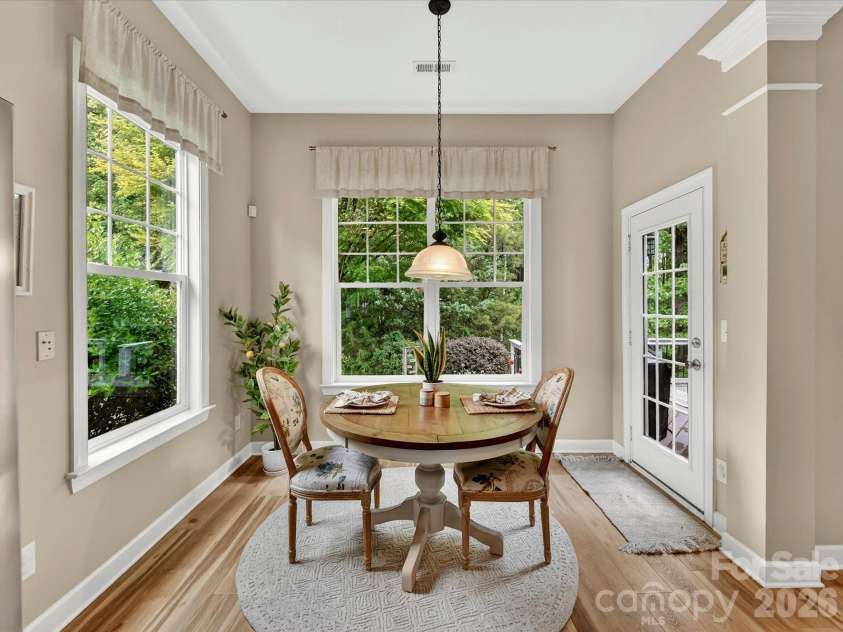 18721 The Commons Boulevard, Cornelius, NC 28031.  MLS# CAR4373232, YatesRealty ID 18371. Bright and cheerful breakfast nook surrounded by windows, offering serene backyard views and the perfect spot for casual dining.