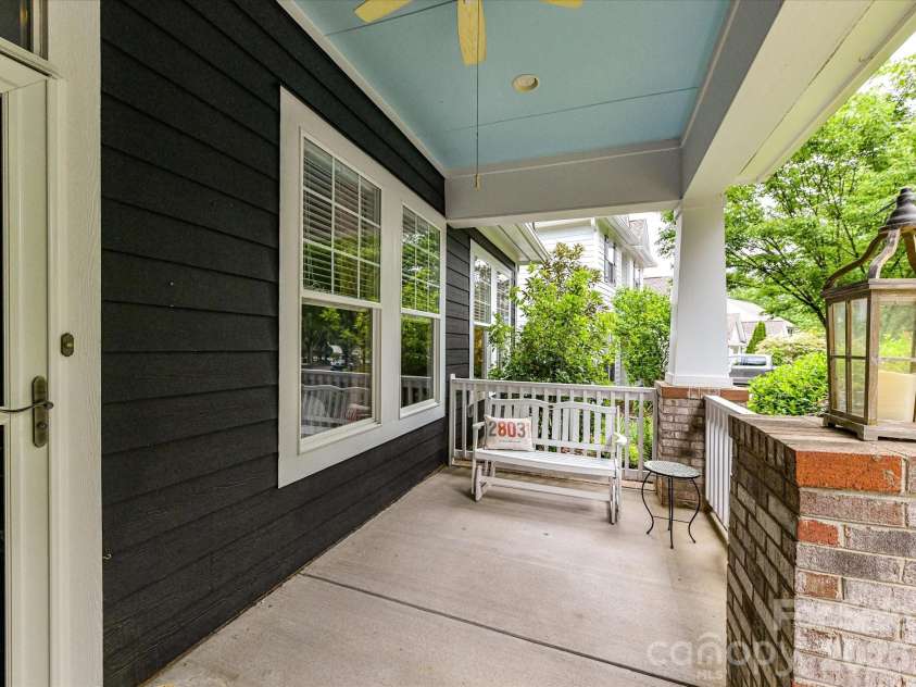 18721 The Commons Boulevard, Cornelius, NC 28031.  MLS# CAR4373232, YatesRealty ID 18371. Inviting covered front porch with charming seating area, ceiling fan, and peaceful neighborhood views—perfect for relaxing or welcoming guests.