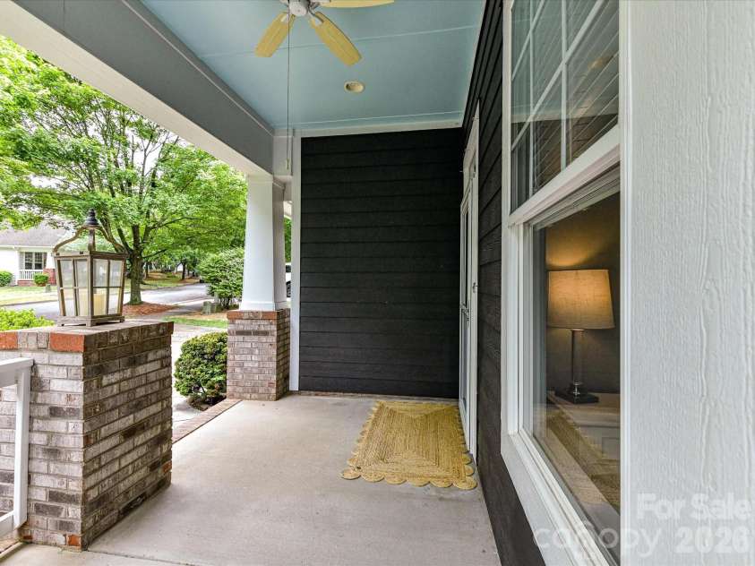 18721 The Commons Boulevard, Cornelius, NC 28031.  MLS# CAR4373232, YatesRealty ID 18371. Inviting covered front porch with charming seating area, ceiling fan, and peaceful neighborhood views—perfect for relaxing or welcoming guests.
