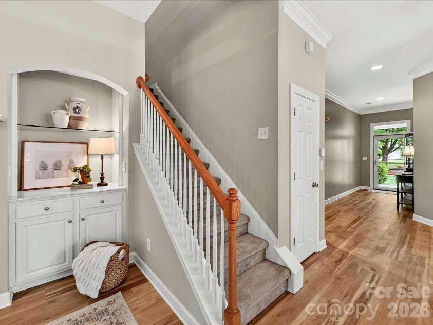 18721 The Commons Boulevard, Cornelius, NC 28031.  MLS# CAR4373232, YatesRealty ID 18371. Inviting stairway with classic white balusters and wood handrail, complemented by warm LVP floors and elegant architectural details.