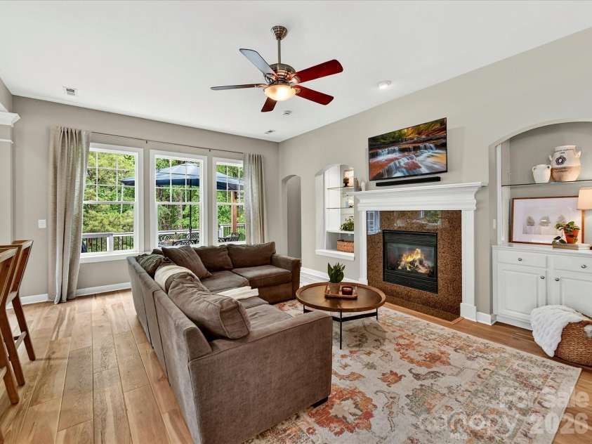18721 The Commons Boulevard, Cornelius, NC 28031.  MLS# CAR4373232, YatesRealty ID 18371. Open-concept great room featuring warm LVP flooring, a statement fireplace, and seamless flow to surrounding living spaces—ideal for everyday living and entertaining.