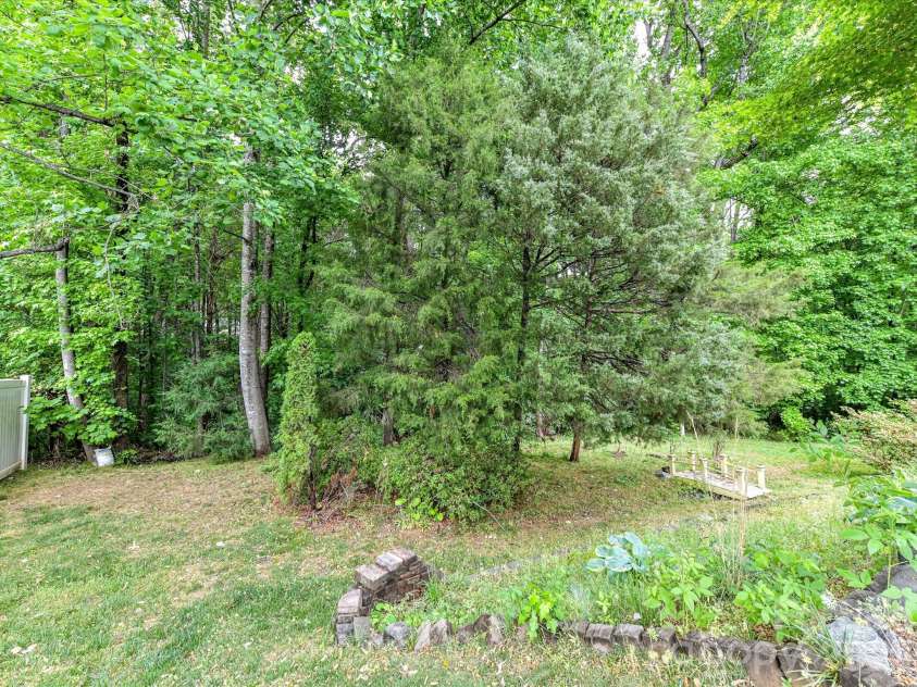 18721 The Commons Boulevard, Cornelius, NC 28031.  MLS# CAR4373232, YatesRealty ID 18371. Private, tree-lined backyard with lush greenery and a peaceful natural setting, perfect for relaxing or enjoying the outdoors.