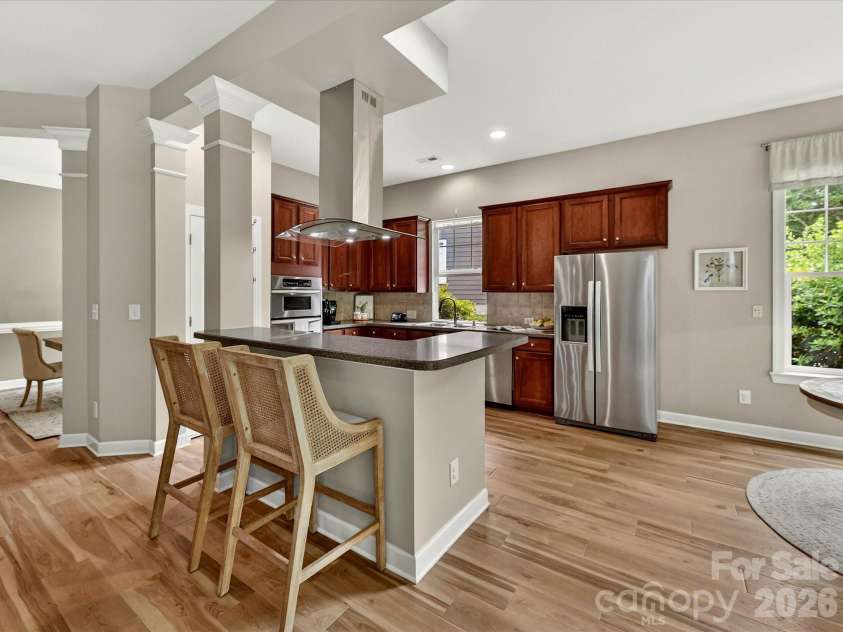 18721 The Commons Boulevard, Cornelius, NC 28031.  MLS# CAR4373232, YatesRealty ID 18371. Spacious kitchen featuring rich cabinetry, stainless steel appliances, ample counter space, and a large island with seating—perfect for cooking and gathering.