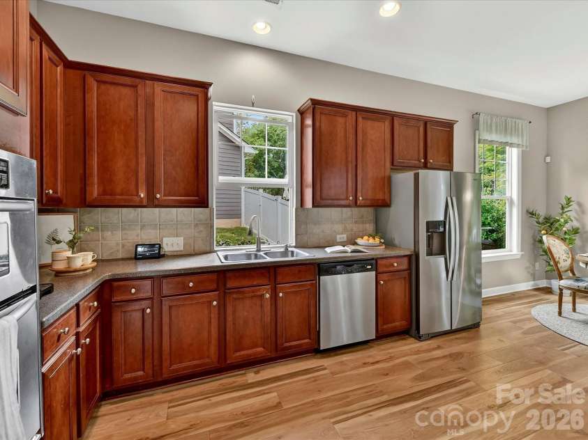 18721 The Commons Boulevard, Cornelius, NC 28031.  MLS# CAR4373232, YatesRealty ID 18371. Spacious kitchen featuring rich cabinetry, stainless steel appliances, ample counter space, and a large island with seating—perfect for cooking and gathering.