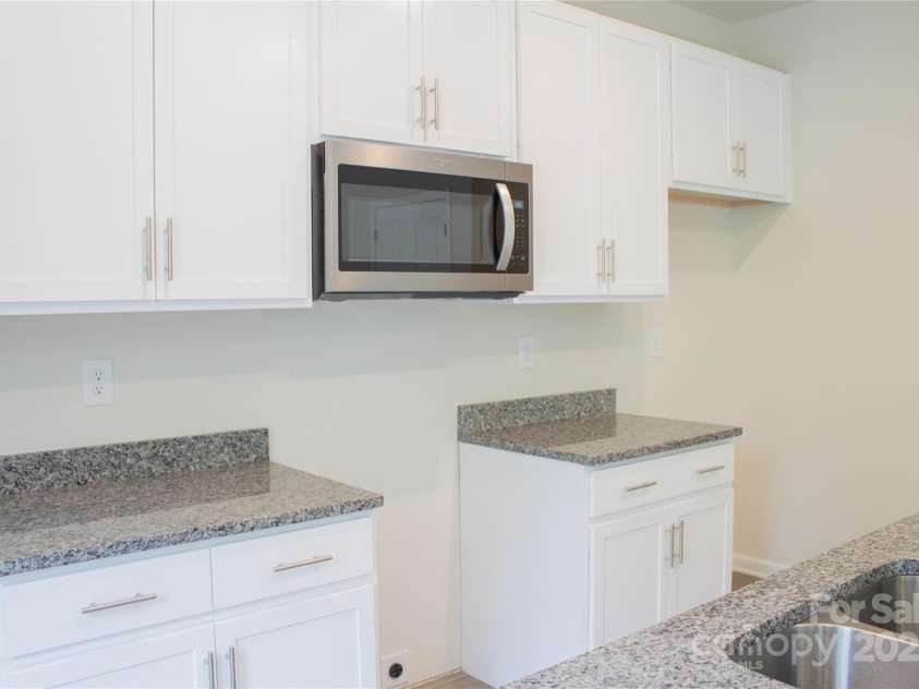 7601 Hammond Drive, Charlotte, NC 28215.  MLS# CAR4267514, YatesRealty ID 18378. Kitchen with white cabinetry and granite countertops, builder offering $1,500.00 appliance allowance.