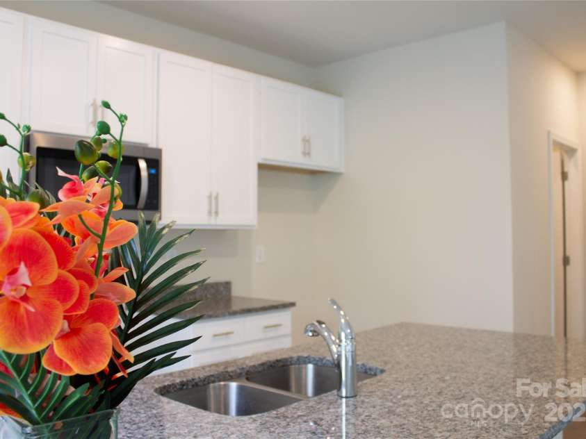 7601 Hammond Drive, Charlotte, NC 28215.  MLS# CAR4267514, YatesRealty ID 18378. Sink is conveniently located in the kitchen island, door to the far right leads to the powder room and then into garage.
