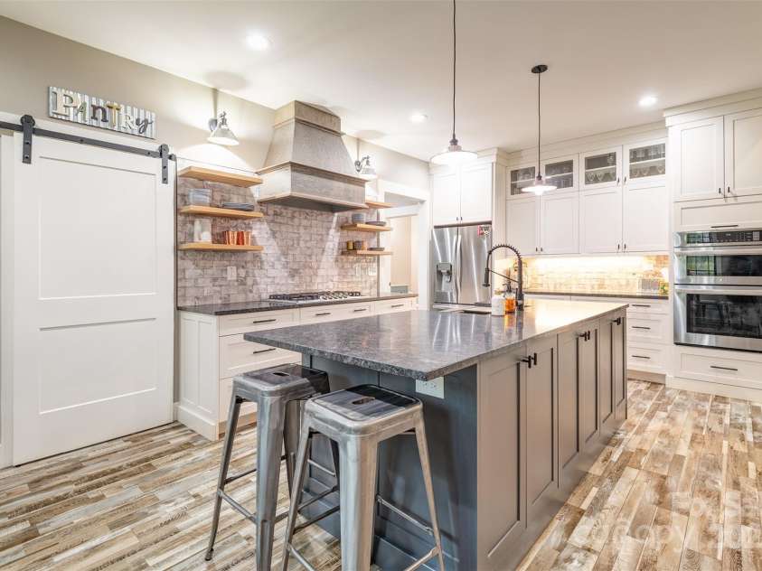 45 Erin Glen Court, Fairview, NC 28730.  MLS# CAR4239316, YatesRealty ID 18382. Kitchen with barn door slider leading into the pantry