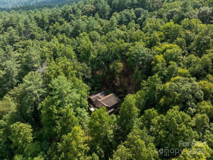 721 Kuenzel Eller Drive, Millers Creek, NC 28651.  MLS# CAR4179124, YatesRealty ID 184. Drone view of home built into the side of the mountain
