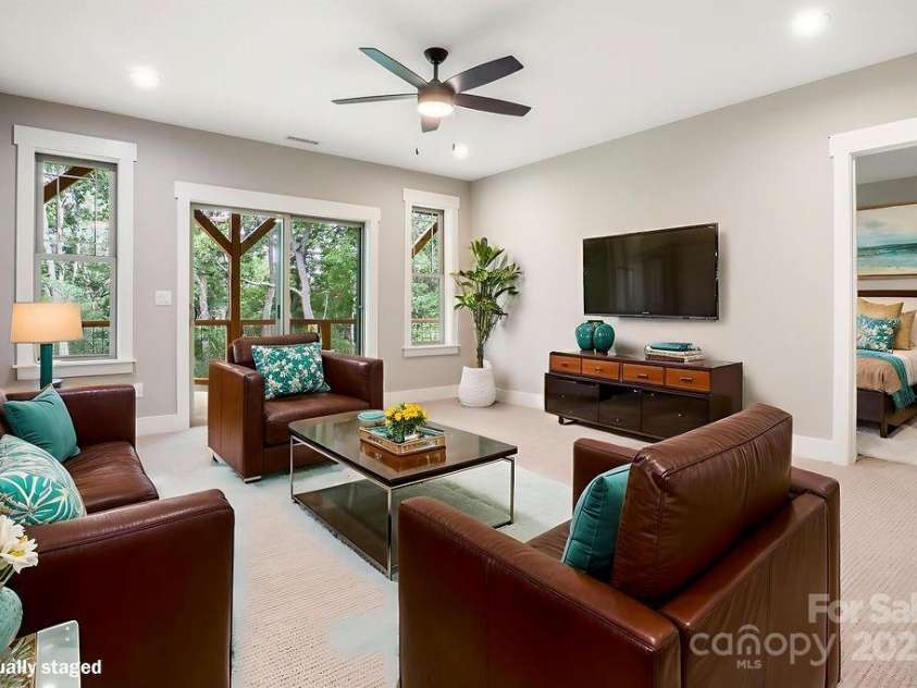 21 Craftsman Overlook Ridge, Arden, NC 28704.  MLS# CAR4007643, YatesRealty ID 18407. Lower level rec room opening to large covered deck overlooking wooded view.