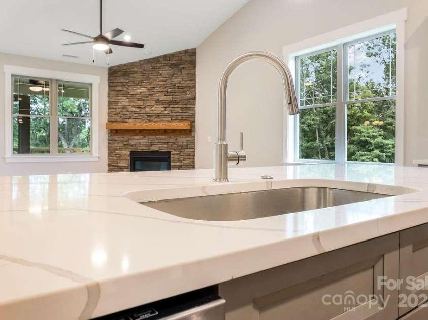 21 Craftsman Overlook Ridge, Arden, NC 28704.  MLS# CAR4007643, YatesRealty ID 18407. Quartz countertop on kitchen island open to great room and French doors overlooking private, wooded view.