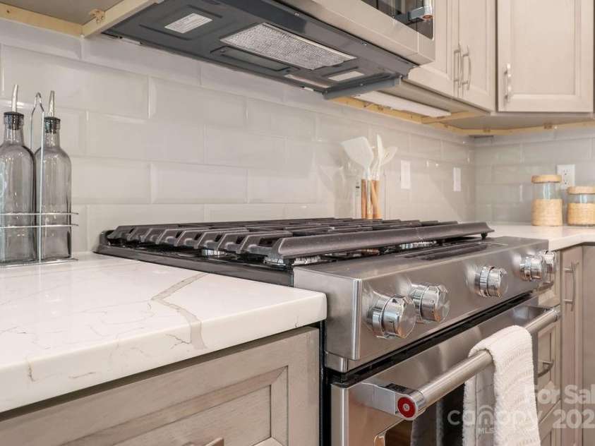 21 Craftsman Overlook Ridge, Arden, NC 28704.  MLS# CAR4007643, YatesRealty ID 18407. Subway tile backsplash, quartz countertops and gas range.