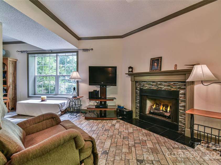 145 Fox Glen Drive, Arden, NC 28704.  MLS# CAR4134713, YatesRealty ID 18409. Daylight basement apartment living room with gas log fireplace