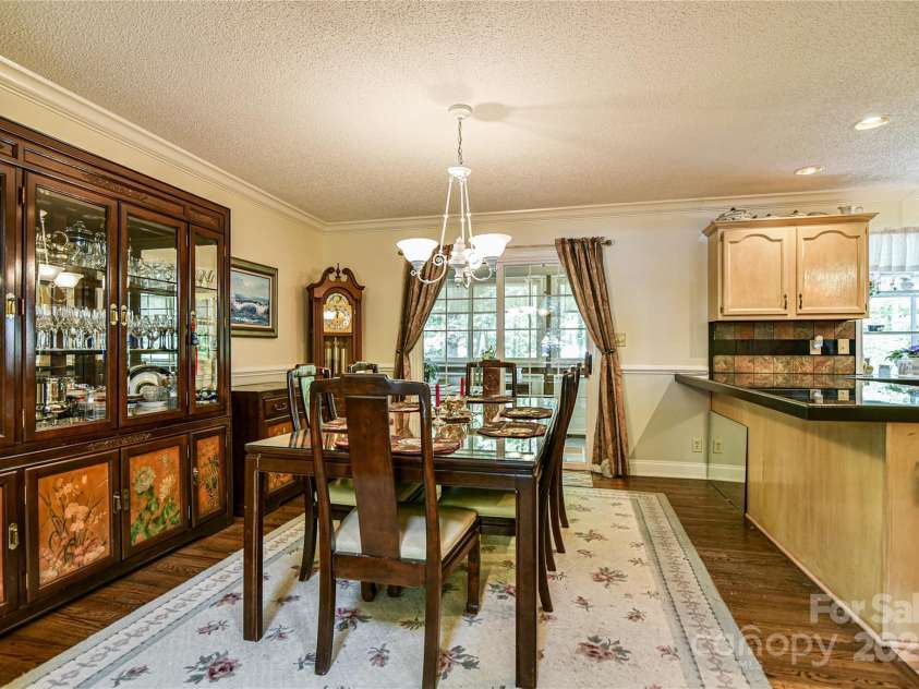 145 Fox Glen Drive, Arden, NC 28704.  MLS# CAR4134713, YatesRealty ID 18409. Open dining room leads to enclosed porch overlooking backyard