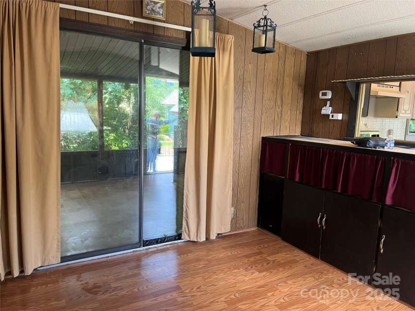 68 Cornwell Drive, Waynesville, NC 28786.  MLS# CAR4265358, YatesRealty ID 18412. Living room towards back screened in porch