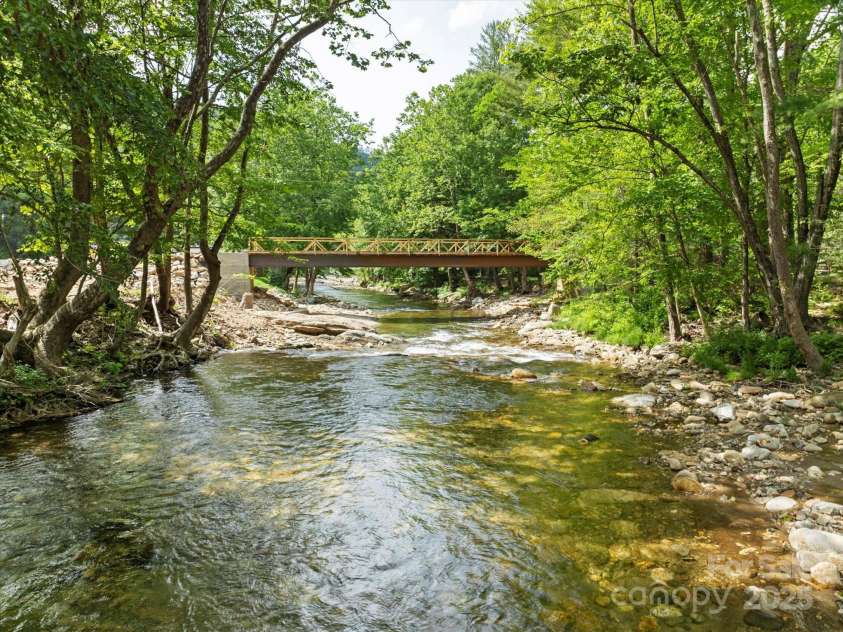 23 Mountain Meadow Lane, Canton, NC 28716.  MLS# CAR4269164, YatesRealty ID 18435. Looking downstream and to the newly installed bridge used to access the property.