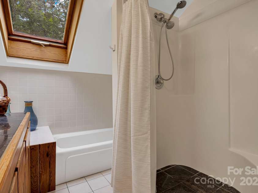214 Laurel Mountain Trail, Saluda, NC 28773.  MLS# CAR4259688, YatesRealty ID 18449. Primary bathroom with tub and shower.