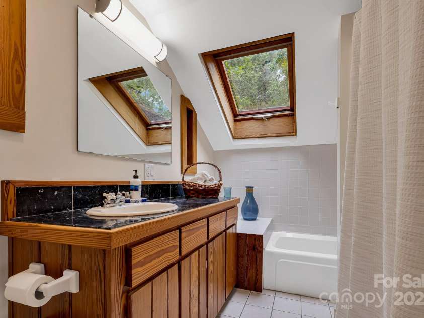 214 Laurel Mountain Trail, Saluda, NC 28773.  MLS# CAR4259688, YatesRealty ID 18449. The primary suite has plenty of storage, a tub and a shower.